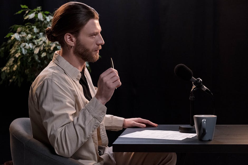 A man recording a podcast in a professional studio environment, engaging with a microphone.